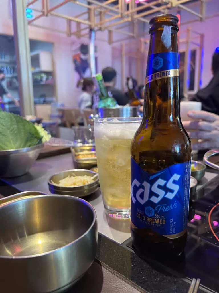 Botella de cerveza coreana Cass en mesa de Korean BBQ