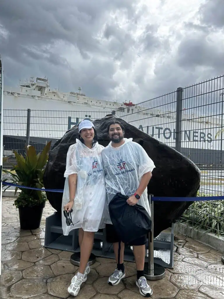 Jackie y Oso con ponchos de lluvia frente al Canal de Panamá en el Centro de Visitantes de Miraflores